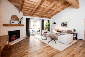 A modern living room with a fireplace, wooden flooring, and a dining area with a table and chairs. - Stylish Mountain-View Townhome with Modern Comforts near Lake Tahoe in Incline Village, Nevada (Incline Village)
