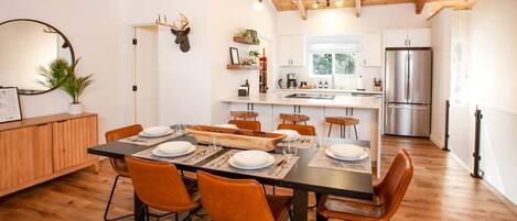 A modern kitchen with a central island, wooden cabinets, and a stainless steel refrigerator.