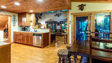 A wooden interior with a kitchen, dining area, and living room.
