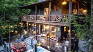 A two-story wooden house with a deck, outdoor seating, and a hot tub. - Scenic Mountain Cabin with Hot Tub, Game Room & Firepit near Silver Run Falls – Cashiers, NC (Cashiers)