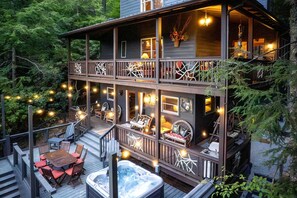 A two-story wooden house with a deck, outdoor seating, and a hot tub. - Scenic Mountain Cabin with Hot Tub, Game Room & Firepit near Silver Run Falls – Cashiers, NC (Cashiers)