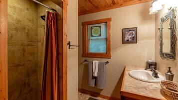 Ein Badezimmer mit Dusche, Waschbecken, einem Fenster mit Jalousien und einem Handtuchhalter.
