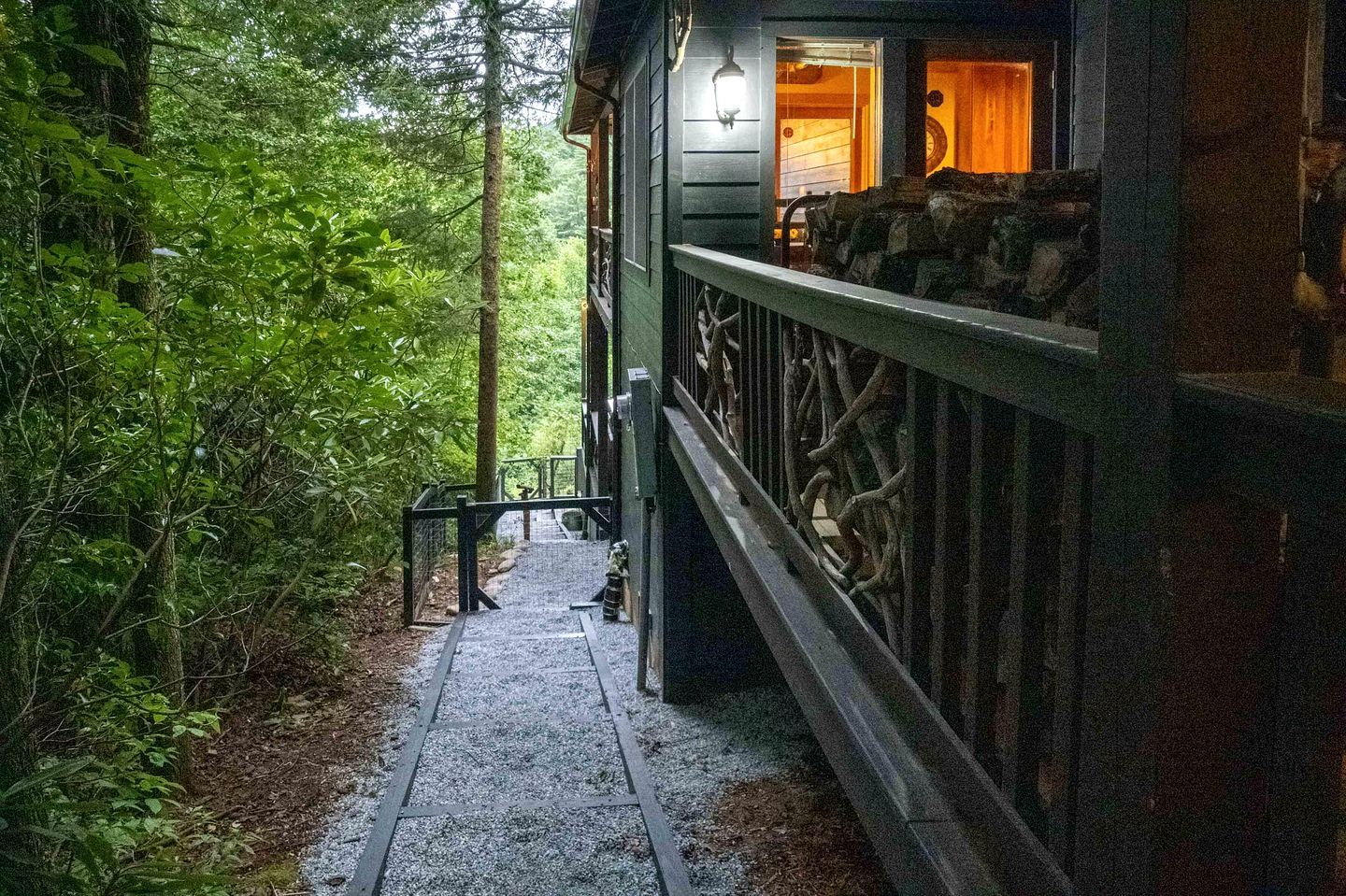 A wooden cabin with a stone pathway leading to a wooden deck.