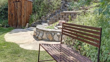 A wooden bench and a stone wall in a garden setting.