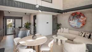 En modern inredning med ett matområde, sittplatser och en stor, abstrakt målning.