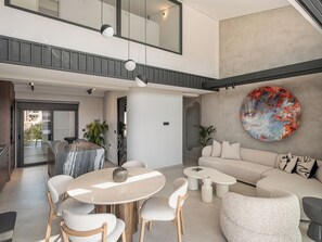 A modern interior with a dining area, seating, and a large abstract painting. - Cosmos Penthouse Suite (Chania)