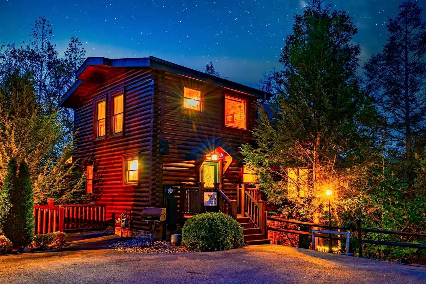 A log cabin with a porch, a front door, and a visible staircase leading to the entrance.