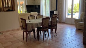 Amplia sala de estar con comedor, chimenea y televisor.