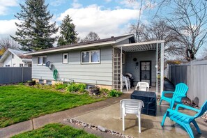 A residential house with a covered patio area, a barbecue grill, and outdoor seating. - Family-Friendly Home with Fire Pit & Cozy Fireplace in Coeur d'Alene, Idaho (Coeur d'Alene)