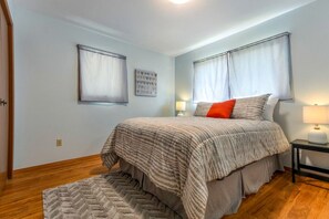 A bedroom with a bed, two bedside lamps, a rug, and two wall-mounted picture frames. - Family-Friendly Home with Fire Pit & Cozy Fireplace in Coeur d'Alene, Idaho (Coeur d'Alene)