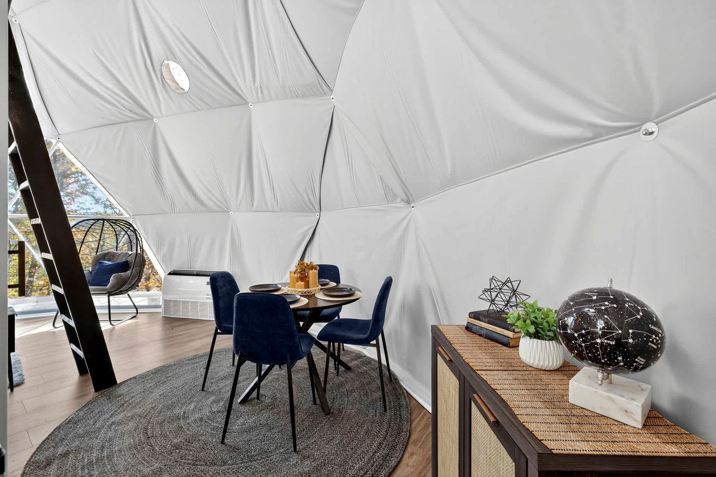 Un comedor con carpas, una mesa, sillas y un globo decorativo.