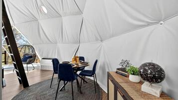 Un comedor con carpas, una mesa, sillas y un globo decorativo.