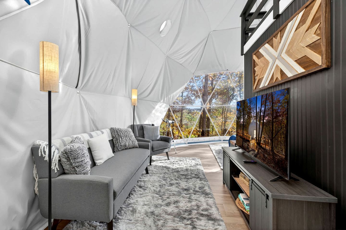 A tented room with a sofa, a TV, and a lamp.
