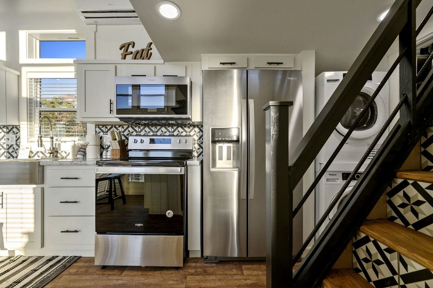 A modern kitchen with a built-in oven, microwave, and stainless steel refrigerator.