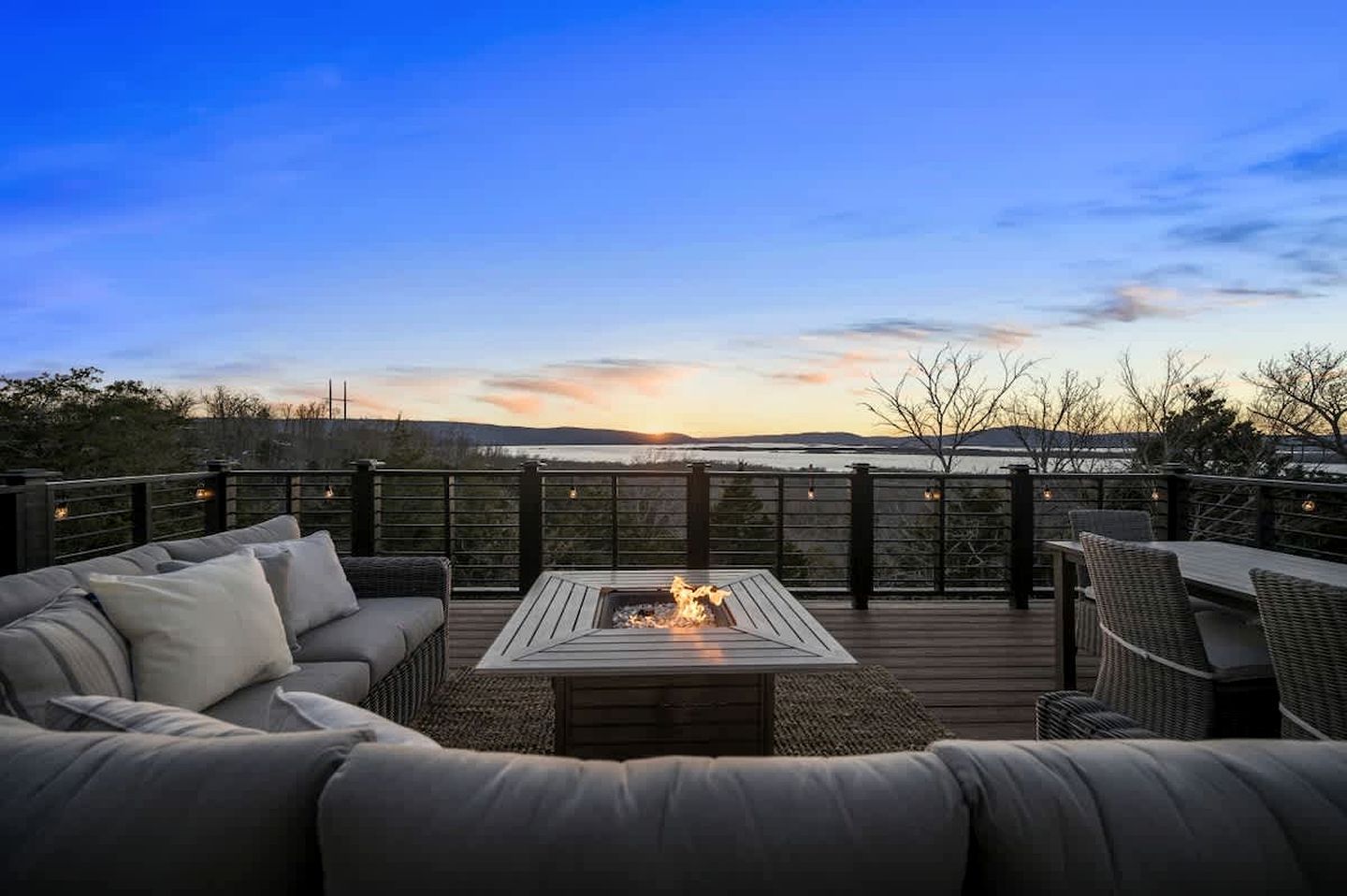 A deck with a fire pit, outdoor furniture, and a view of the landscape.
