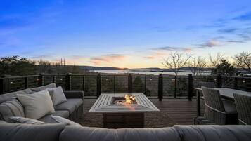A deck with a fire pit, outdoor furniture, and a view of the landscape.
