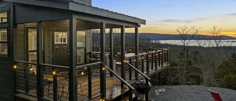 Un edificio moderno con terraza, mobiliario exterior y vista al paisaje.
