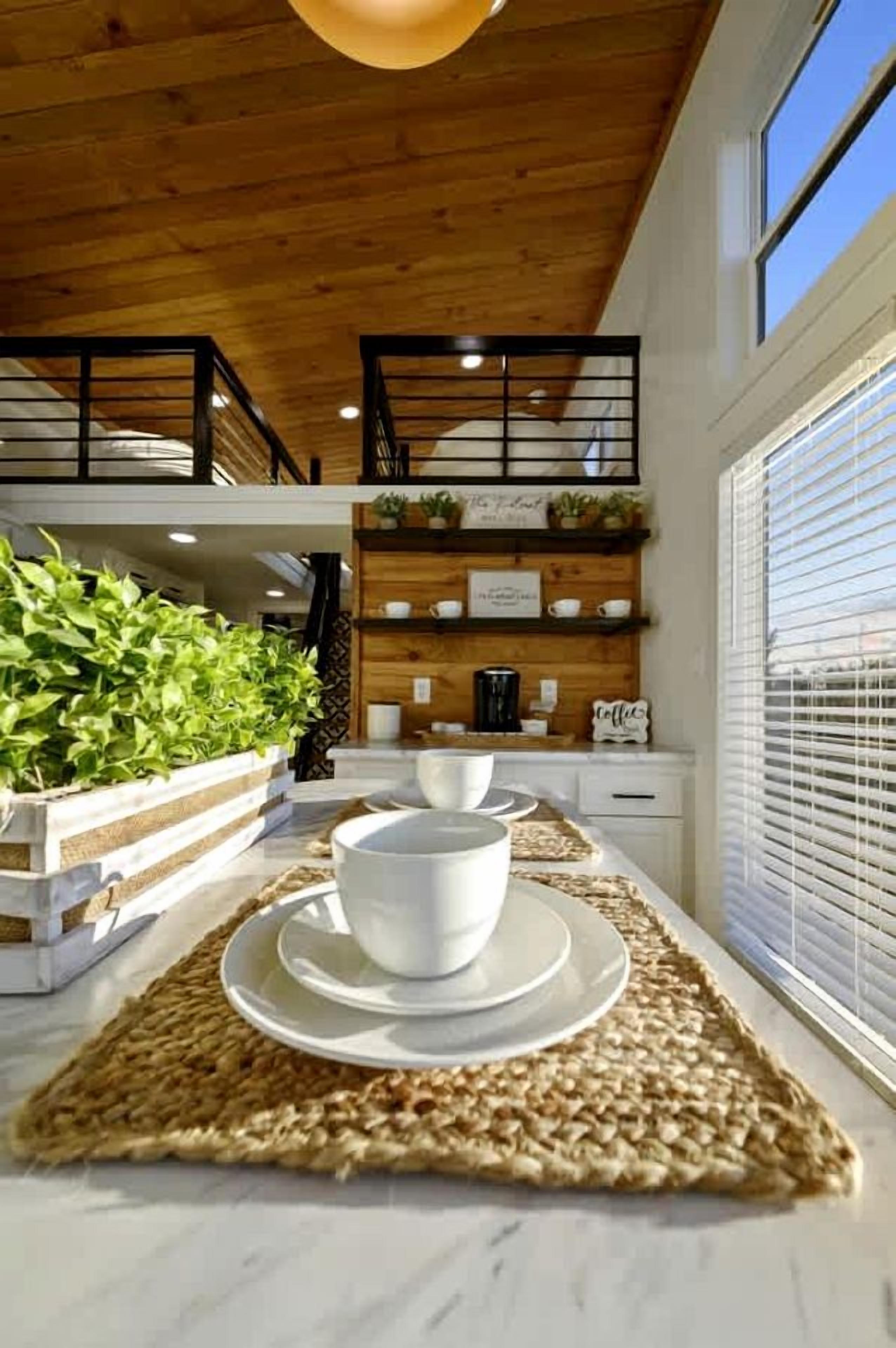 A modern kitchen with a wooden ceiling, a coffee station, and a view of the outdoors.