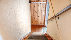 A staircase with wooden steps leading up to a landing with a wooden wall.