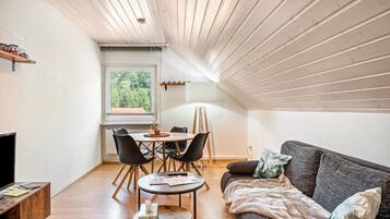 Un acogedor espacio tipo loft con comedor, sofá y televisor.