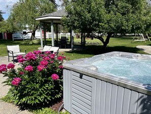 A hot tub with a gazebo and chairs in a backyard. - Spacious 5BR Retreat with Hot Tub & Fire Pit Near Coeur d'Alene (Coeur d'Alene)