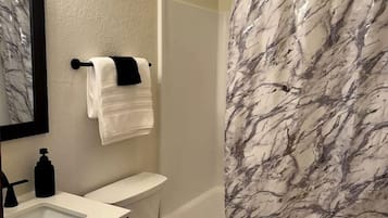 Ein Badezimmer mit Toilette, Waschbecken und Duschvorhang.
