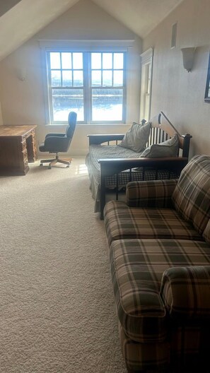 A room with a large window, a desk, a chair, a couch, and a bed. - Peaceful Waterfront Retreat with Fire Pit & Nature-Filled Surroundings in McCall, Idaho (McCall)