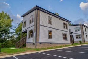 A two-story building with a covered staircase, a parking lot, and a clear sky. - Stylish Pigeon Forge Cabin with Hot Tub & Resort Amenities near Gatlinburg Golf Course, TN (Pigeon Forge)