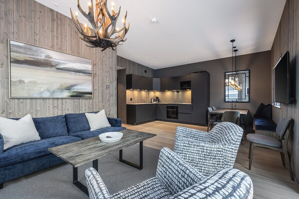 A modern living room with a sofa, patterned armchair, and a coffee table.