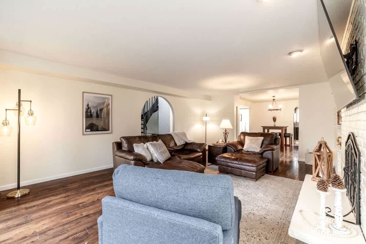 A spacious living room with a large sofa set, a coffee table, and a fireplace.