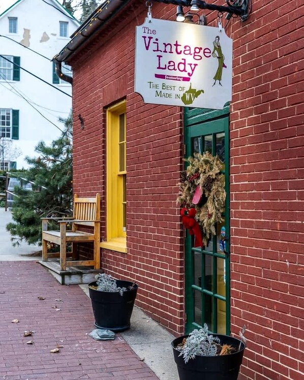 A brick building with a sign reading 'The Vintage Lady' and a green door.