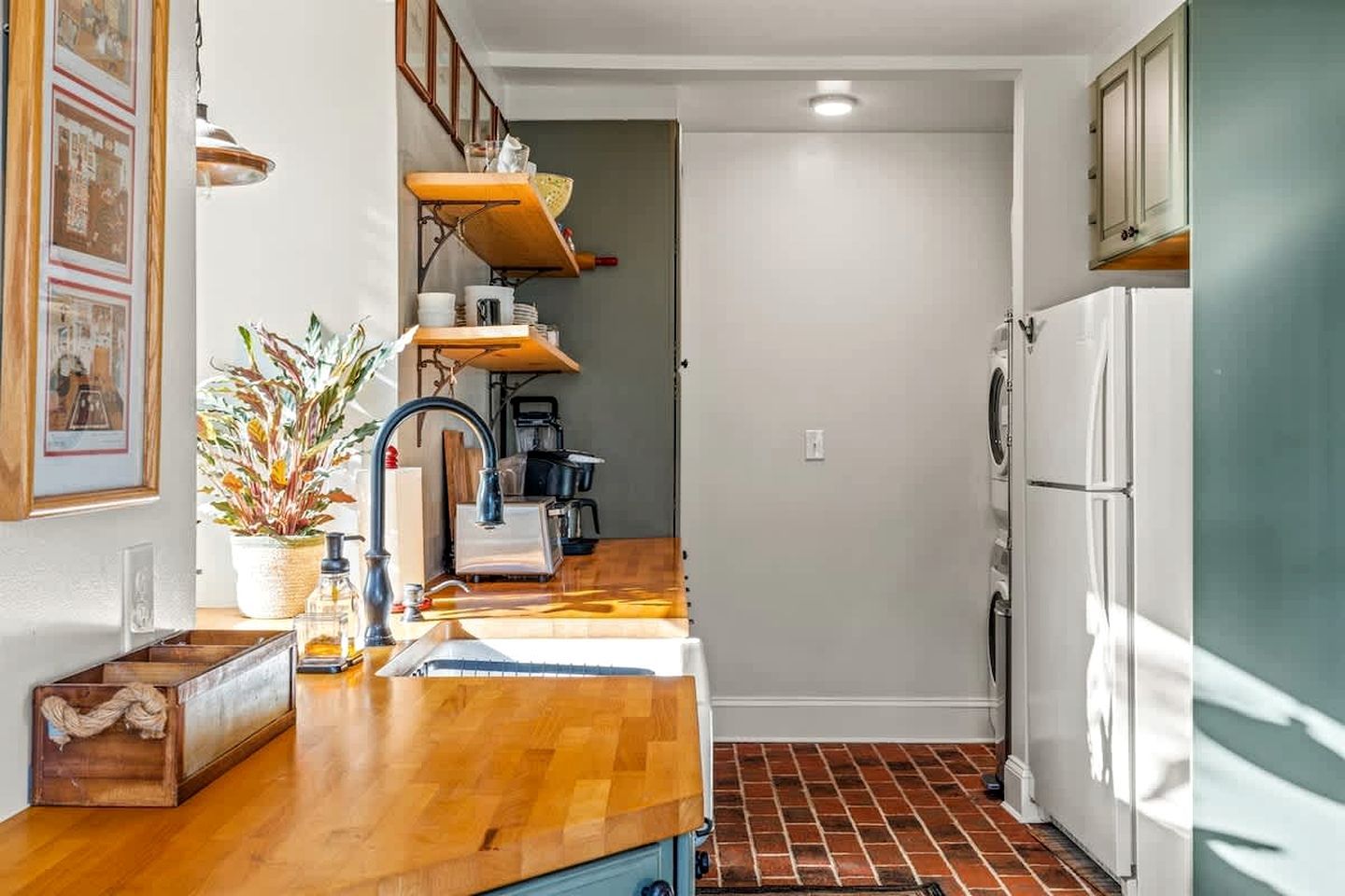 A compact kitchen with a wooden countertop, a sink, a stove, and a refrigerator.