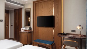 A hotel room with a bed, a desk with a chair, a television, a coffee maker, and a bedside table. - Aspera Hotel Taksim (Istanbul)