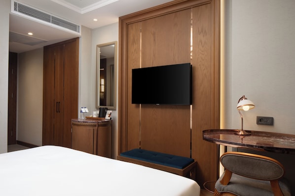 A hotel room with a bed, a desk with a chair, a television mounted on the wall, and a wardrobe. - Aspera Hotel Taksim (Istanbul)