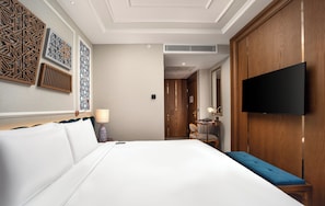 A hotel room with a large bed, a flat-screen TV mounted on the wall, a wooden wardrobe, and decorative wall panels. - Aspera Hotel Taksim (Istanbul)