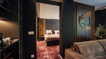 Moderni hotellihuone, jossa on sänky, punainen matto, puukoristeinen seinä ja seinään kiinnitetty valaisin.