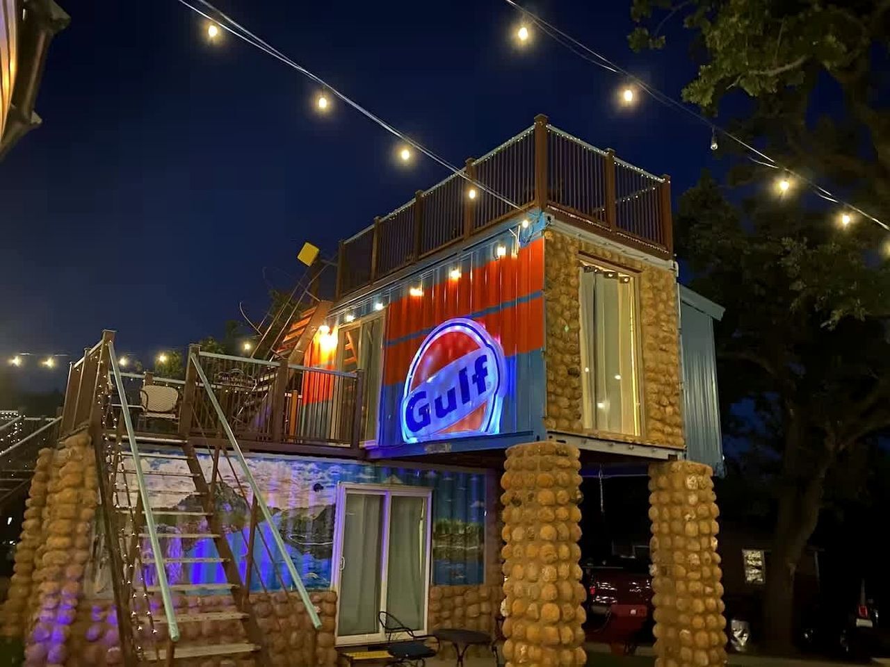 Un edificio con un letrero que dice 'Gulf', un balcón y una escalera que baja a un nivel inferior.