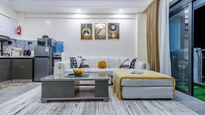Una sala moderna con sofá, mesa de centro y un área de lavandería con paredes de vidrio.