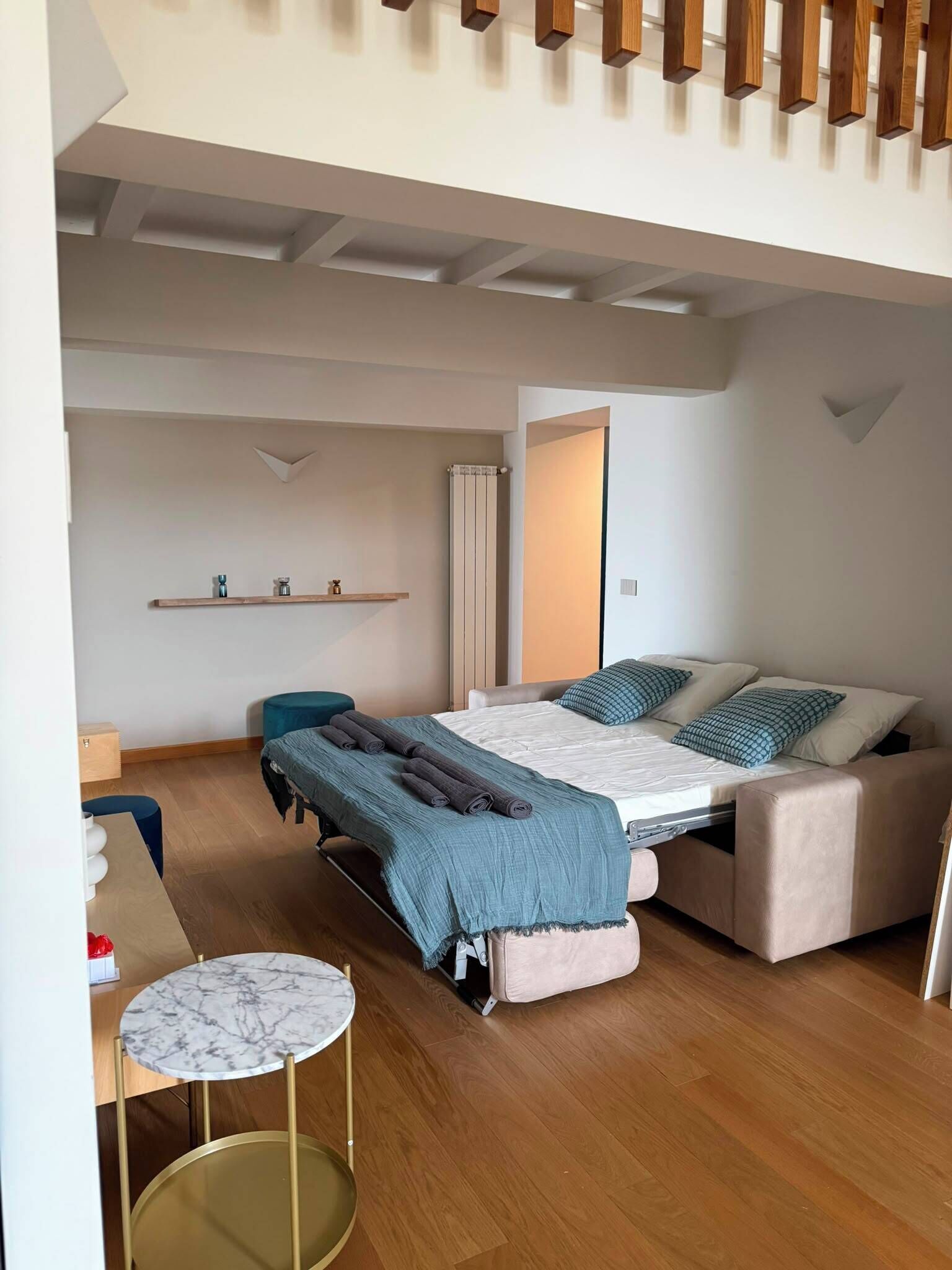 Ein modernes Schlafzimmer mit Bett, Nachttischen, einem Schreibtisch und einem Sessel.