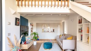 A modern living room with a sofa, ottoman, and bookshelf. - La Casa di Joy (Naples)