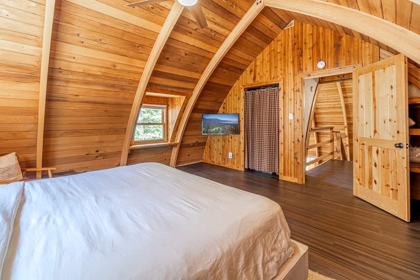 Une chambre à coucher avec un lit, une télévision et une fenêtre.