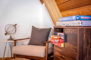 A room with a wooden cabinet, a chair, and a globe on a small table. - Stunning Canoe-Frame Cabin with Private Hot Tub near Lake Tahoe Beaches in Incline Village, Nevada (Incline Village)
