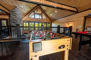 Ein Fußballtisch in einem Raum mit Holzwänden und einer Steinsäule.