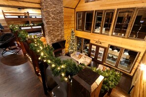 Ein gemütliches Interieur mit Kamin, Weihnachtsbaum und einer Sitzecke mit Blick ins Freie.