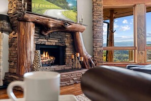 Una chimenea de piedra con diseño de leña, una pantalla para chimenea y velas.