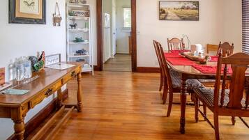 A dining area with wooden furniture, a red tablecloth, and a farmhouse-themed decor.