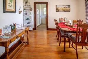 Un coin repas avec des meubles en bois, une nappe rouge et une décoration sur le thème de la ferme.