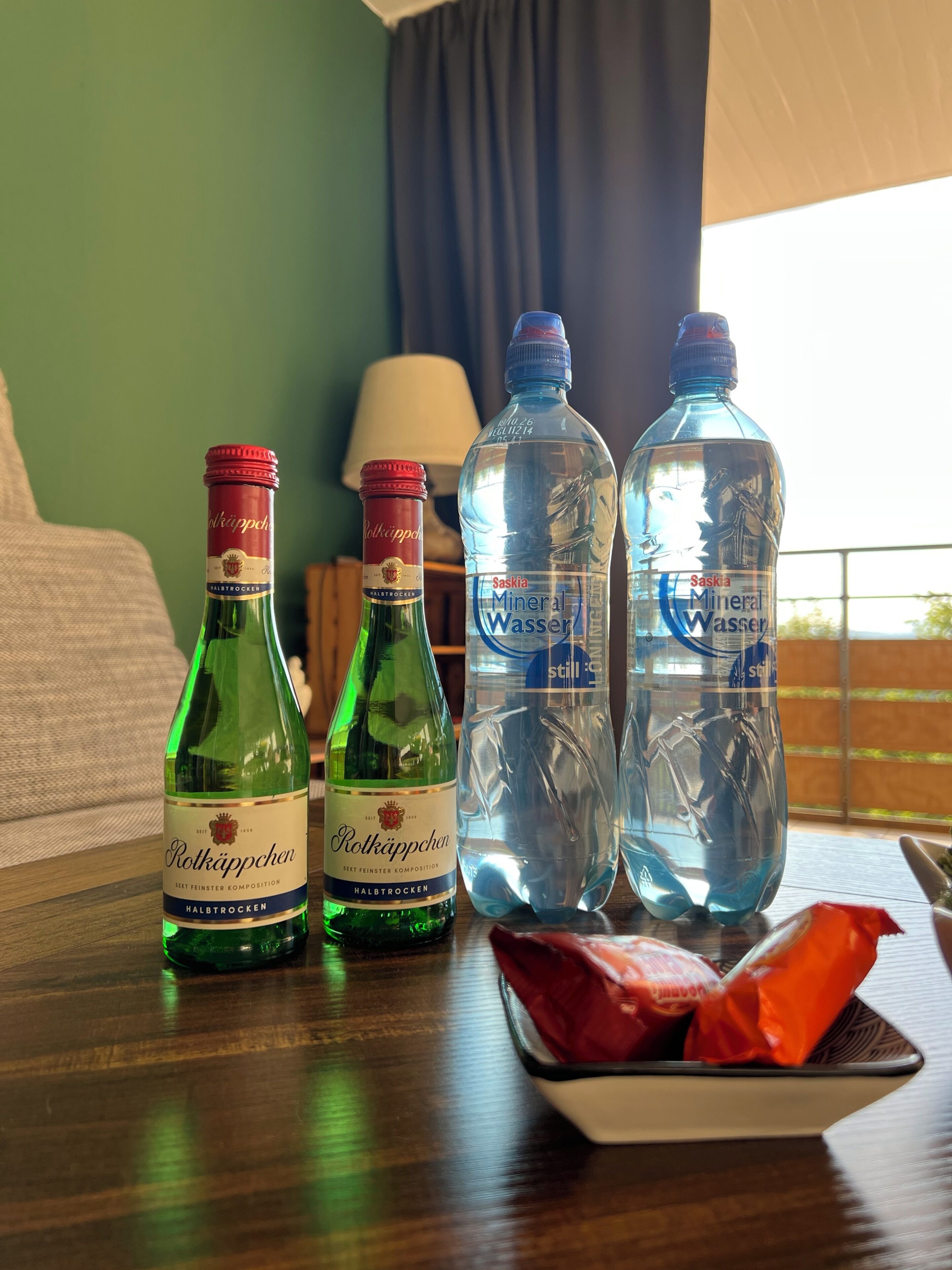 Zwei Flaschen Röttler Bier und zwei Flaschen Saskia Mineralwasser auf einem Holztisch.