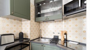 A kitchen with a toaster, a kettle, a sink, and a microwave. - A modern and welcoming 55-square-meter apartment, ideal for up to 4 guests, located on the first floor of a building with an elevator. The property is situated in Brenta, a quiet residential area a short distance from Porta Romana and the new Scalo Roman (Milan)