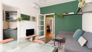 A compact living space with a dining table, a sofa, a TV, and a kitchen area. - A modern and welcoming 55-square-meter apartment, ideal for up to 4 guests, located on the first floor of a building with an elevator. The property is situated in Brenta, a quiet residential area a short distance from Porta Romana and the new Scalo Roman (Milan)